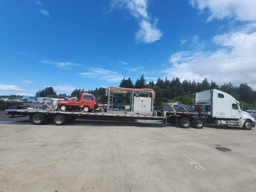 Stepdeck trailer hauling marine equipment as a Partial Truckload (PTL) from Oregon to California, showcasing long-haul shipping for specialized freight