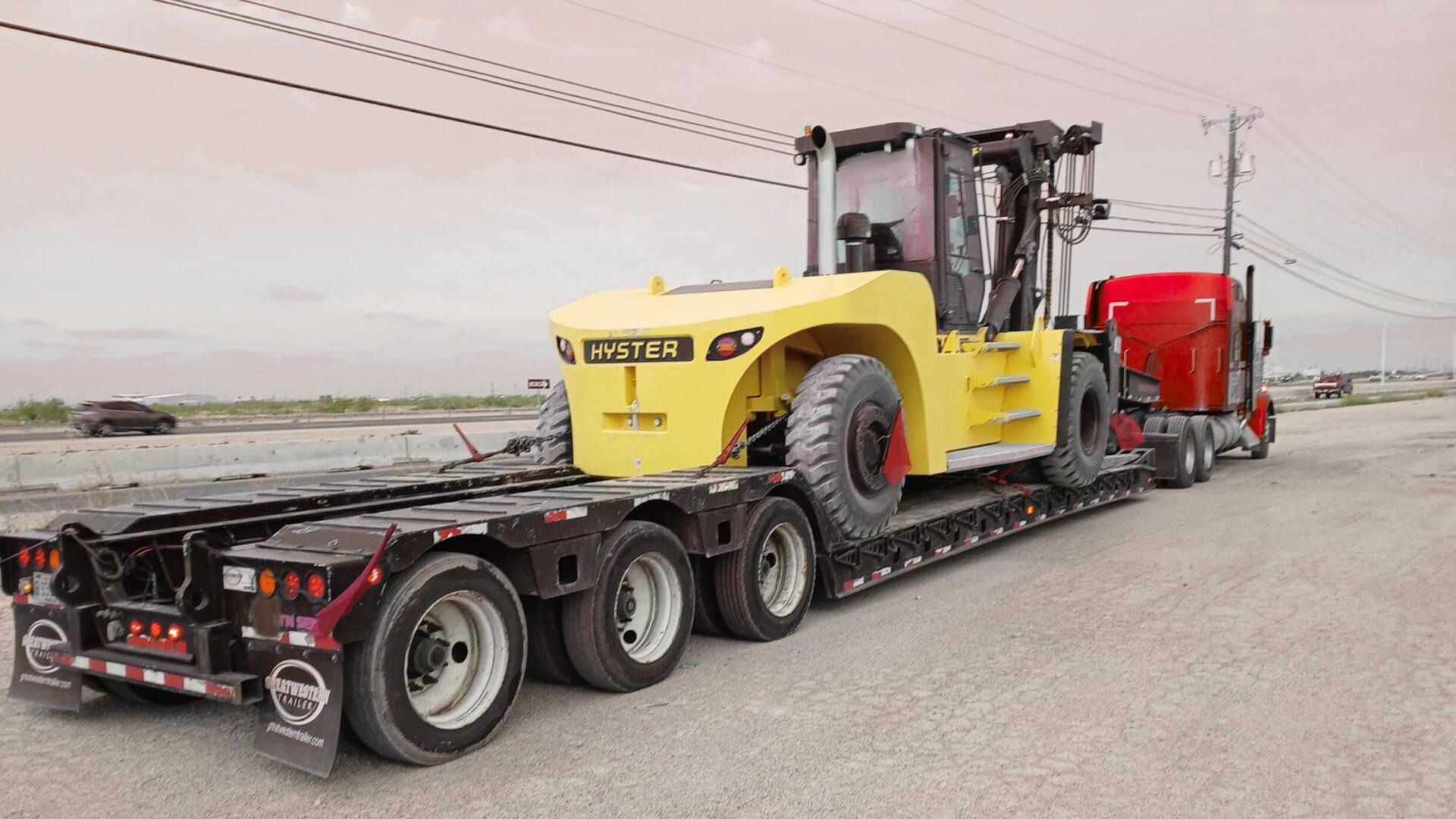 Heavy haul oversized freight service visual showing RGN lowboy trailer loaded for transport by Abound Transport