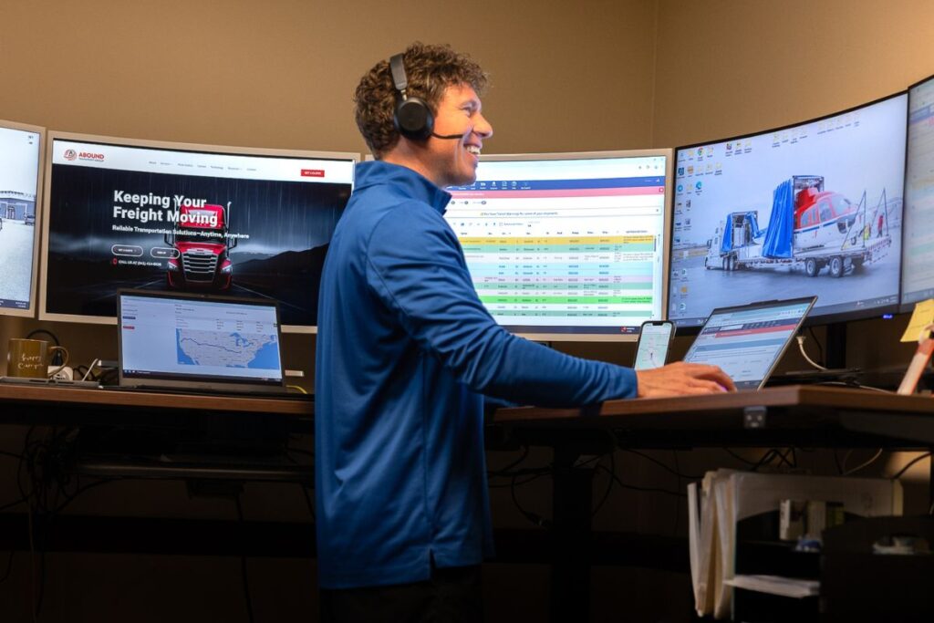 TJ Orton freight agent working at his desk coordinating shipments at Abound Transport office
