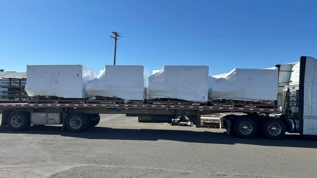 Truck bodies secured on a flatbed trailer for expedited freight transport by Abound Transport.