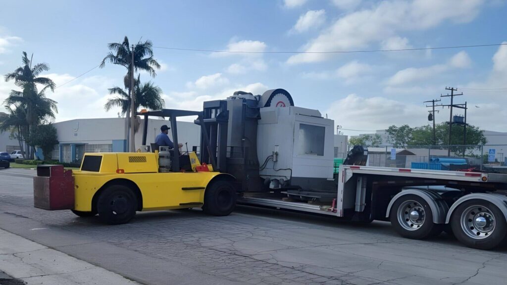 HAAS VF-6 CNC milling machine being rigged and secured on a double drop trailer for transport by Abound Transport.