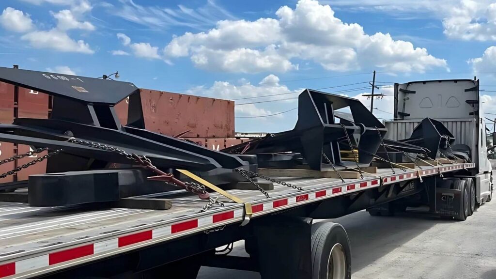 Ship anchors secured on a flatbed trailer for freight transport by Abound Transport.
