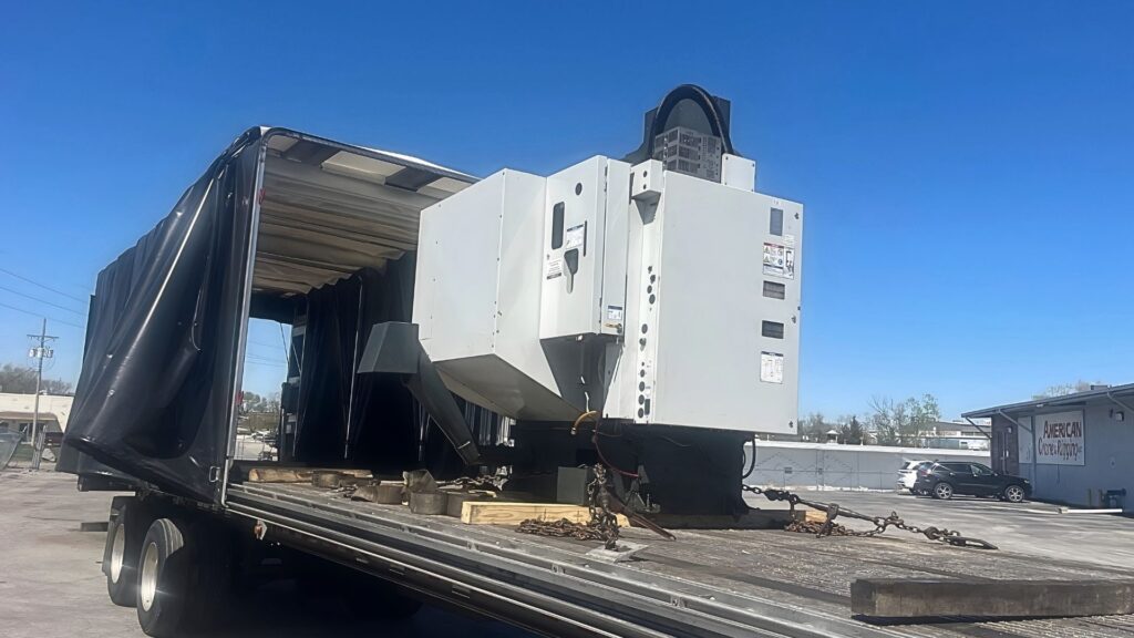 CNC machine loaded on Conestoga flatbed trailer for partial truckload shipping by Abound DeckShare