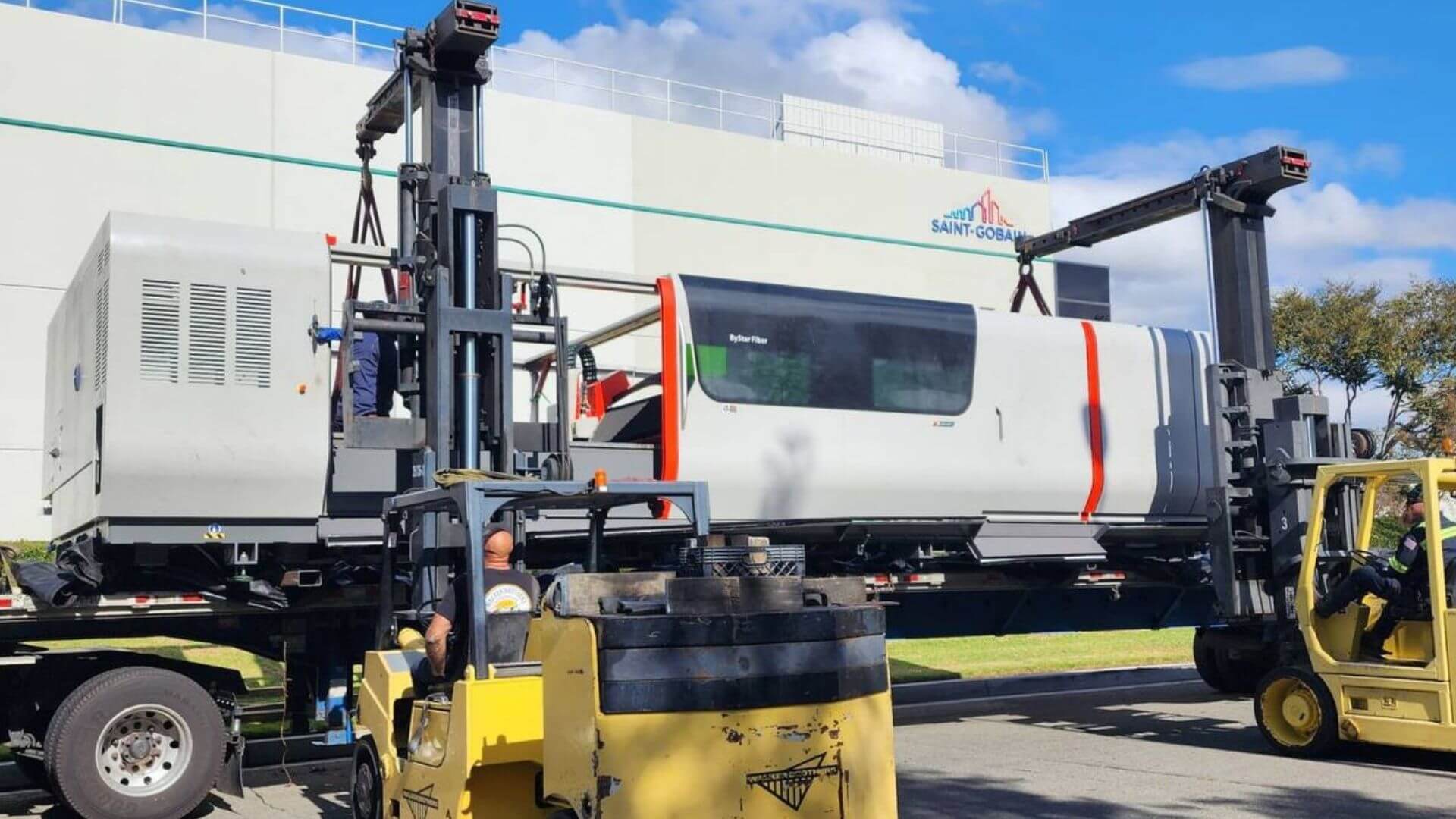 CNC machine being forklifted off a flatbed trailer by Abound Transport
