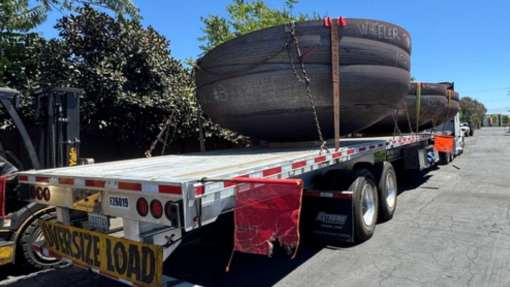 Large industrial tank secured on a flatbed trailer for transportation