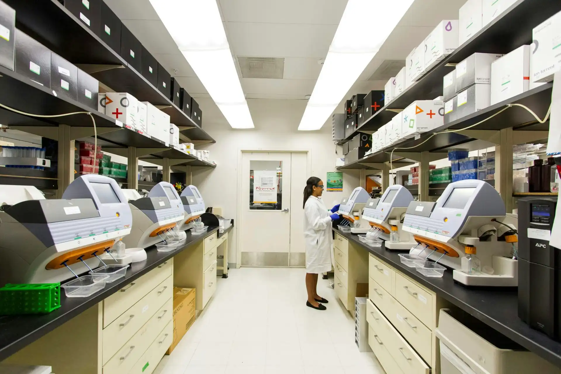 Scientist working in high-tech laboratory with automated diagnostic equipment for pharmaceutical and medical freight transport