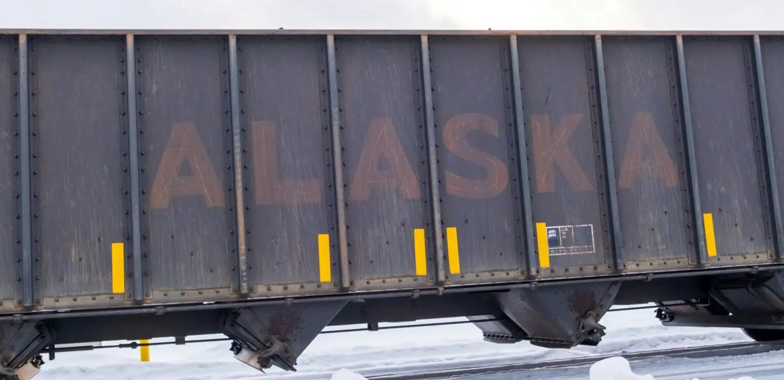 Alaska Railroad covered hopper rail car transporting bulk materials and freight across snow-covered tracks