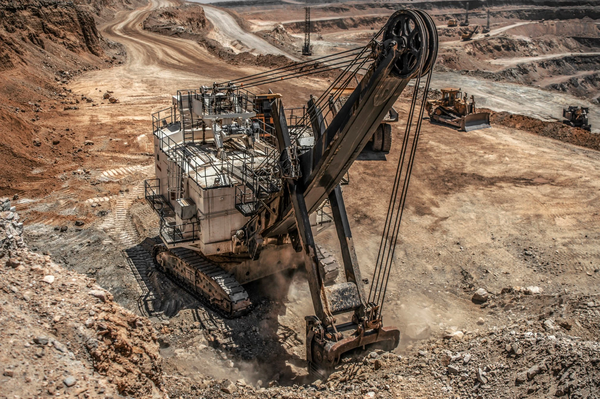 Massive electric rope shovel excavator operating in an open-pit mining pit for heavy equipment and machinery logistics