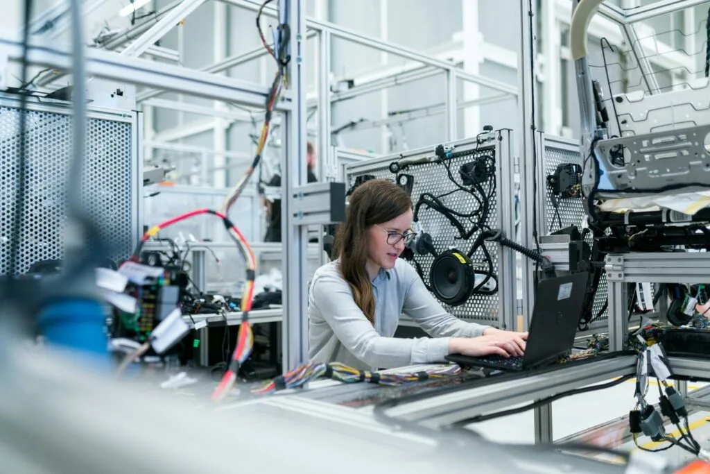 Engineer working on laptop in industrial manufacturing plant
