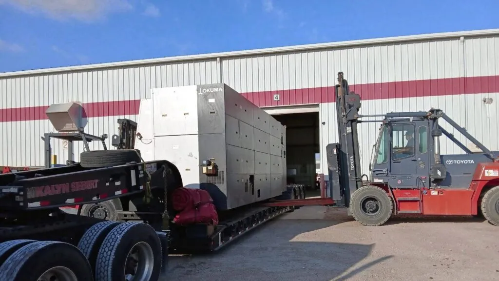 Okuma CNC machine secured on a heavy haul trailer for transport by Abound Transport.
