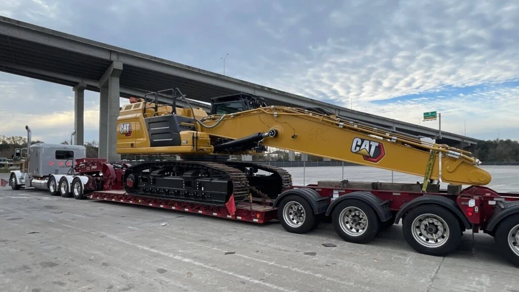 Construction equipment loaded on flatbed trailer for nationwide freight delivery