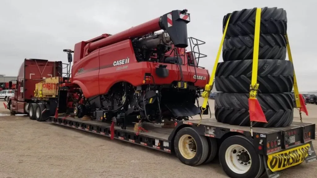 farm equipment loaded on a double drop trailer