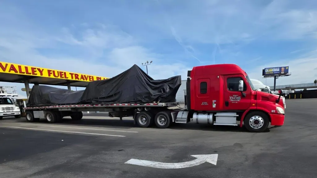 tarped cnc machinery on a flatbed trailer example perfect tarp job for cnc transport example by Abound Transport
