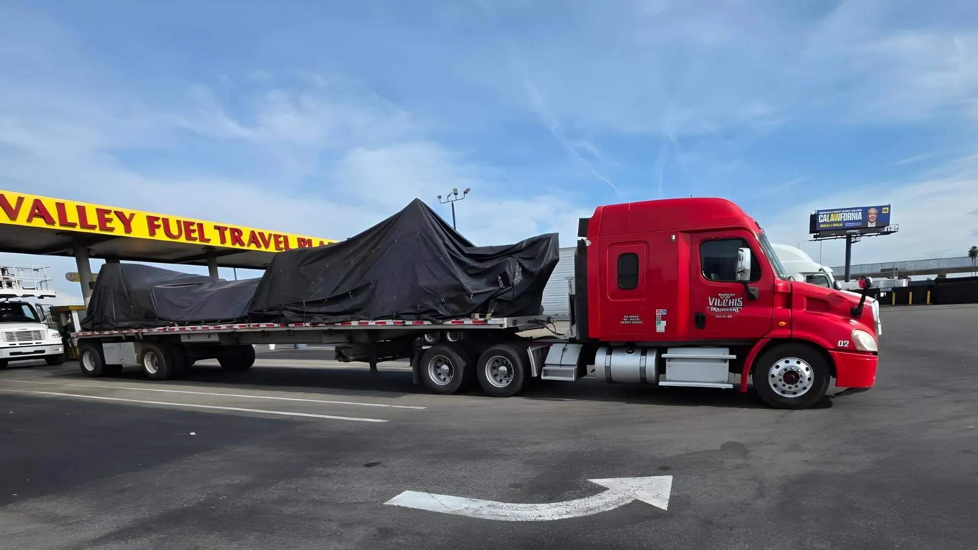 tarped cnc machinery on a flatbed trailer example perfect tarp job for cnc transport example by Abound Transport
