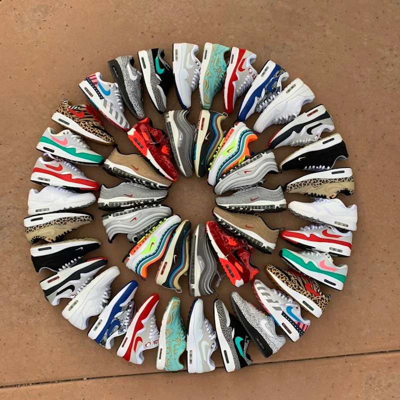 Collection of colorful Nike Air Max sneakers arranged neatly in concentric circular wheels on pavement