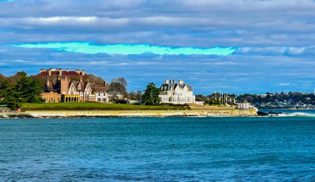 Historic waterfront mansions along the coastline of Newport Rhode Island overlooking calm blue ocean waters