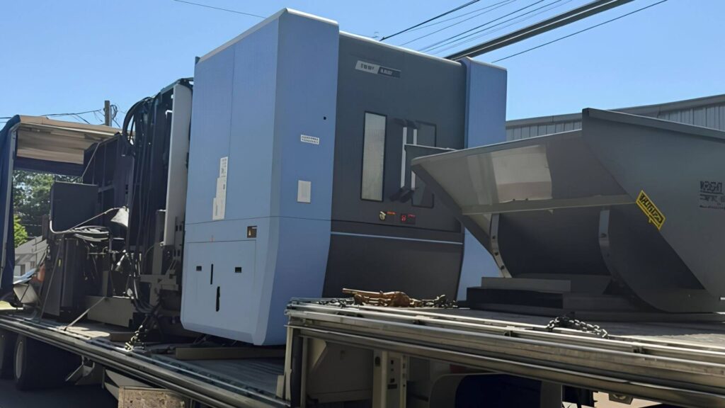 CNC lathe being prepared by machinery riggers for transport near Seattle Washington